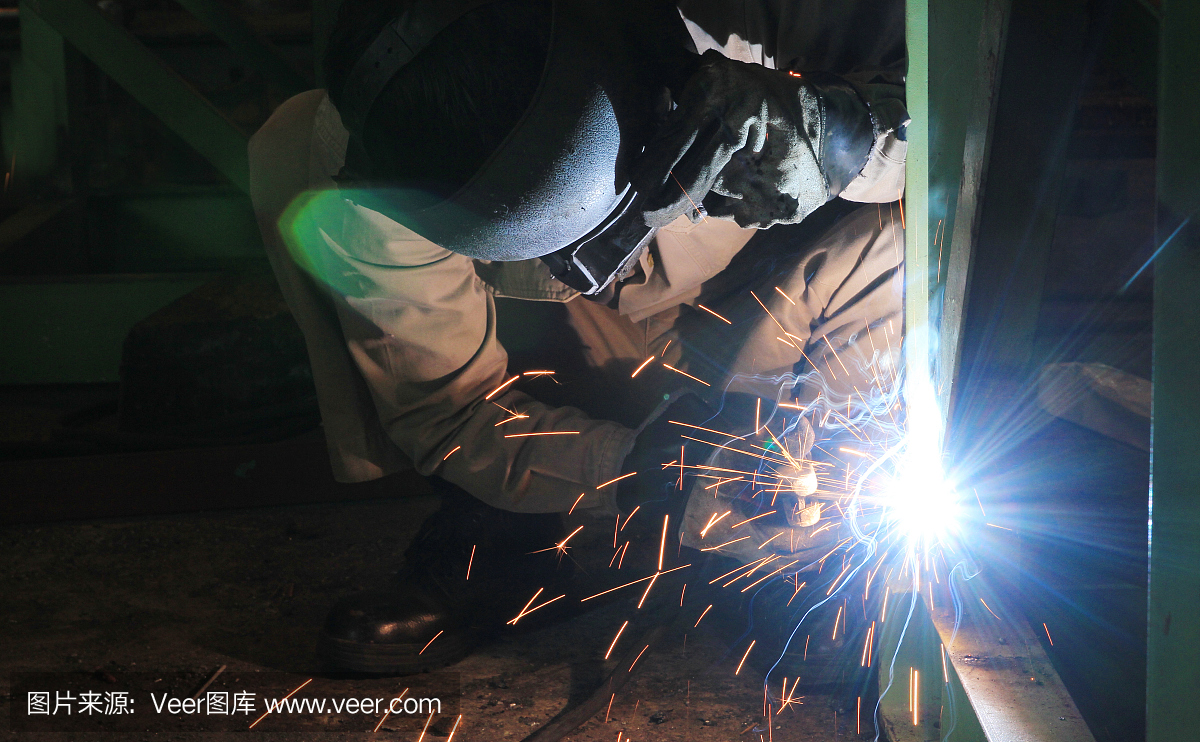 工业工人焊接钢结构。